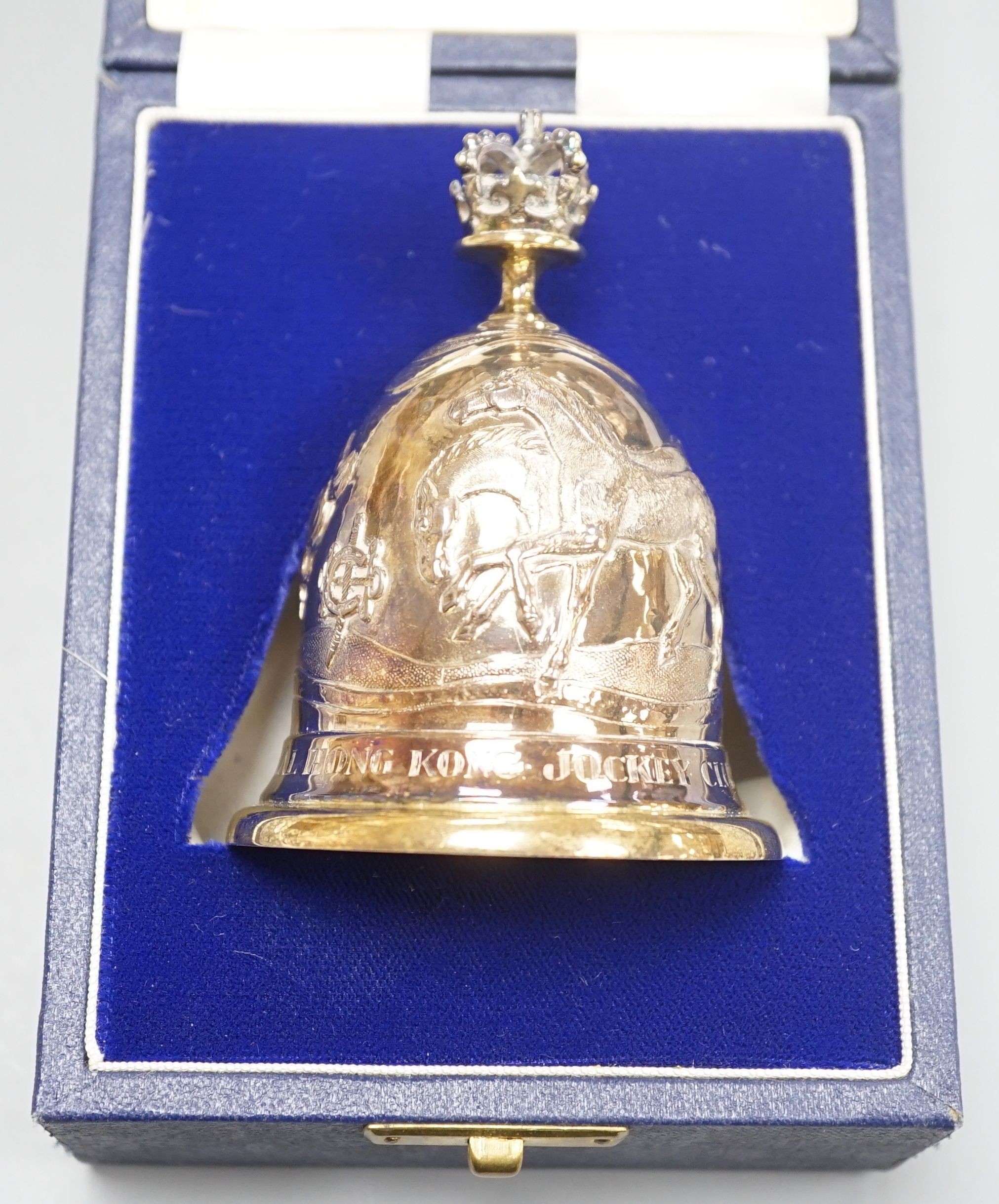 A cased modern embossed silver gilt hand bell, with engraved inscription, 'The Royal Hong Kong Jockey Club Centenary, 1884-1984', Garrard & Co, London, 1985, 94mm, 126 grams.